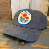 Gray cap with California poppy design on a wooden surface.