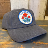 Gray cap with California poppy design on a wooden surface.