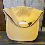 Yellow cotton dad hat turned inside out on a rustic wooden table, showing stitched details and interior seams.