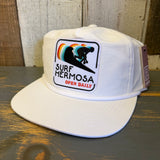 White cotton hat with a surfer patch and colorful wave design, suitable for daily wear.