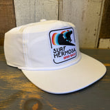 White cotton hat with a colorful surfer patch and OPEN DAILY text, ideal for casual, everyday wear.