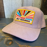 Dusty rose five-panel corduroy cap with sunrise patch on front, suitable for casual or outdoor use.