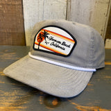 Beige corduroy cap with Hermosa Beach California patch on a wooden surface