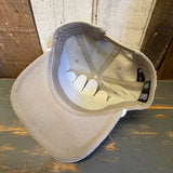 underside of a beige corduroy cap with Hermosa Beach California patch on a wooden surface
