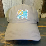 beige cap with a beach chair and sun design on a wooden surface