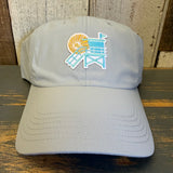 light grey cap with a beach chair and sun design on a wooden surface