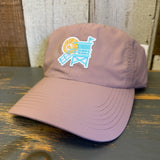 dusty rose cap with a beach chair and sun design on a wooden surface