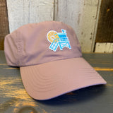 dusty rose cap with a beach chair and sun design on a wooden surface