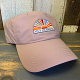 dusty rose baseball cap with colorful Muy Hermosa logo on a wooden surface