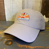 Beige cap with colorful Muy Hermosa patch on a wooden surface
