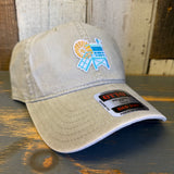 Stone cotton dad hat with LIFEGUARD TOWER text, 6-panel low profile, displayed on rustic wooden surface.