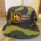 Camo 6-panel hat with yellow-orange embroidered front detail, suitable for casual wear.
