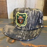 Green camo 5-panel hat with a Smokey Bear patch; cotton material, suitable for outdoor or casual wear.