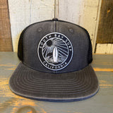 Black 6-panel mesh trucker hat with surfboard patch and CA logo, suitable for casual or outdoor wear.