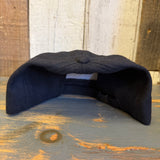 Black 6-panel strapback surf hat made of fabric, displayed on a wooden surface.