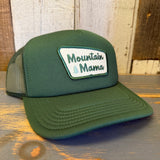 Forest green foam trucker cap with recycled mesh and a tree patch, designed for casual outdoor wear.