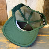 Foam trucker cap, flipped upside down, rests on a rustic multicolored wooden surface.