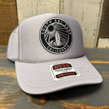 Light gray high crown trucker hat with black SOUTH BAY SURF patch and OTTO sticker, mesh back for breathable wear.