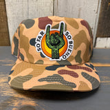 Camo 5-panel hat with a patch showing a cactus in a hand rock sign; durable and suitable for everyday wear.
