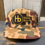 Camo 5-panel workhorse hat with front logo embroidery, suitable for outdoor use.