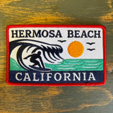 Embroidered Hermosa Beach patch featuring a surfer, birds, and sun; multicolor fabric, suitable for decorating jackets or bags.
