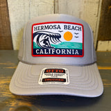 Grey high crown trucker hat with mesh back and sun, wave, and birds patch on front. Suitable for casual outdoor use.