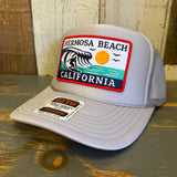 Gray high crown trucker hat with foam front and a colorful wave patch, designed for casual, everyday wear.