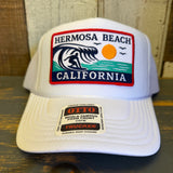 White high crown trucker hat with mesh back and surf patch, ideal for beachwear.