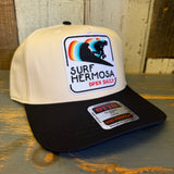 Black and natural 5-panel mid-profile cap featuring a Surf Hermosa Open Daily text and surfer graphic; casual cotton style.