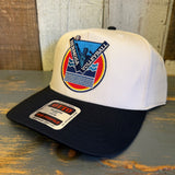 Black and natural 5-panel volleyball cap on rustic wood surface, featuring cotton material for casual outdoor use.