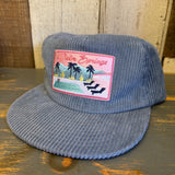Slate blue corduroy field trip hat with a Palm Springs patch on the front. Suitable for casual outdoor wear.