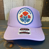 Lavender trucker hat with mesh back and orange poppy design. Suitable for casual outdoor use.