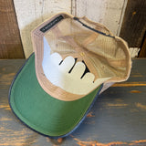 Black and white mesh trucker cap with volleyball text rests on a weathered wooden surface, suitable for casual wear.
