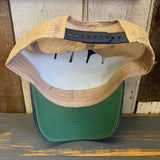 Green six-panel trucker cap with mesh back, displayed upside down on a wooden surface.