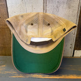 Brown and khaki six-panel trucker cap, displayed upside down to reveal its green brim and adjustable strap.