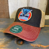 Black, cardinal, and khaki volleyball trucker cap with mesh back on a wooden surface.