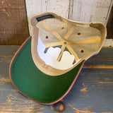 Green-brimmed trucker cap flipped to reveal inner panels, displayed on a wooden surface.