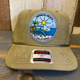 Olive green corduroy cap featuring a sun, palm tree, lifeguard tower, and wave patch. Suitable for casual wear.