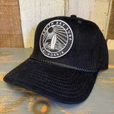 Black corduroy baseball cap with SOUTH BAY CALIFORNIA patch, displayed on a wooden surface.