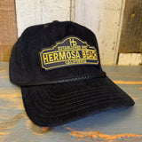 Black corduroy cap with gold embroidered text, ideal for casual wear.