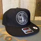 Black 5-panel snapback hat with structured front, canvas material, adjustable fit, and SOUTH BAY SURF patch.