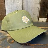 Desert green cotton dad hat with mini logo, displayed on a rustic wooden surface. Suitable for casual wear.
