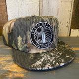 Black 5-panel hat with a South Bay California patch and adjustable snapback, designed in surf camo style.