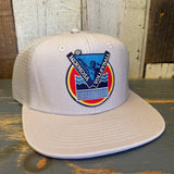 Faded bone 6-panel trucker hat with volleyball patch, mesh back, and adjustable snap closure.