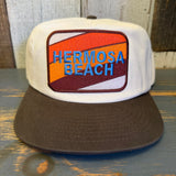 Two-tone snapback hat with a colorful patch, designed for casual wear; adjustable closure ensures a comfortable fit.