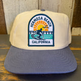 Two-tone slate blue and natural snapback hat with 1 to 3 FEET & RISING patch; adjustable fit for daily wear.