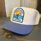 Slate blue and natural snapback hat with patch featuring surfer and sunset, designed for everyday casual wear.