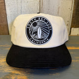 Two-tone black and natural snapback hat with a black patch, adjustable fit, durable material for everyday use.