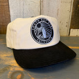 Two-tone black and natural hat with black patch, adjustable snapback closure; suitable for casual wear.