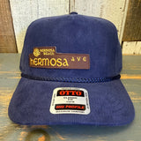 Navy blue corduroy baseball cap featuring a “HERMOSA AVE” patch and OTTO Classic Fit sticker, suitable for casual wear.